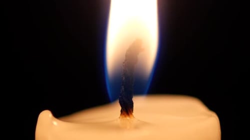 Gros plan d'une flamme de bougie sur fond noir