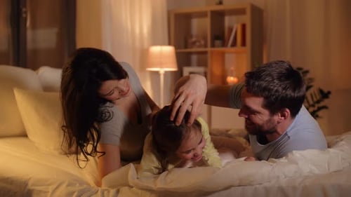 Playful Family Tickling in Cozy Bed at Night