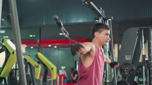 Caucasian Active fitness trainer or athlete male workout exercise pulling weight machine in stadium.