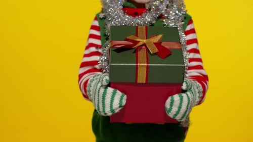 Child Holds Stacked Christmas Gifts with Ribbons