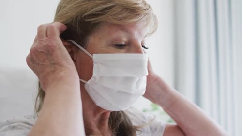 Senior Woman Putting on Protective Face Mask