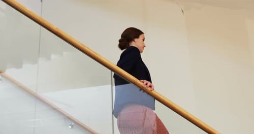 Business Woman Walking Upstairs in Modern Office