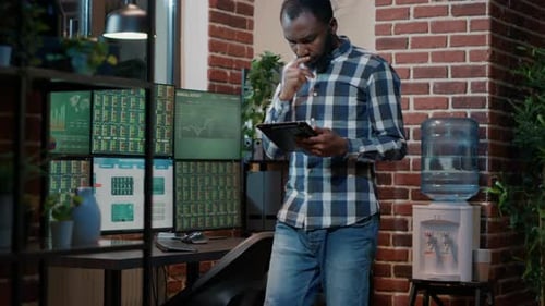 Man Working Late With Tablet Analyzing Data