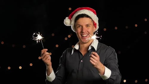 Man Wearing Santa Hat with Sparklers at Night