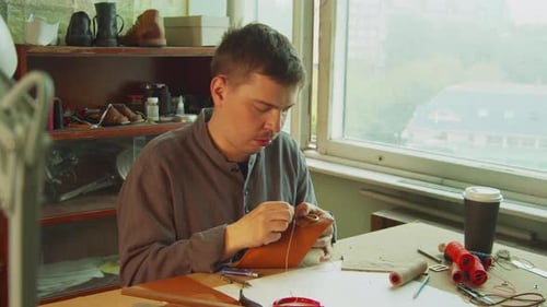 Ein exklusiver Schneider der alten Schule stellt in der Werkstatt handgefertigte Produkte aus echtem Leder her