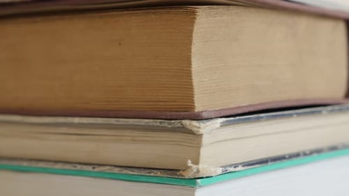 Pile of old books darkened with shelf dust 4K 2160p 30fps UltraHD tilting footage - Close-up of v