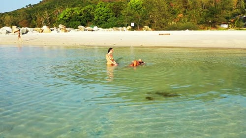Pretty happy ladies on holiday enjoying life at the beach on summer white sandy and blue background