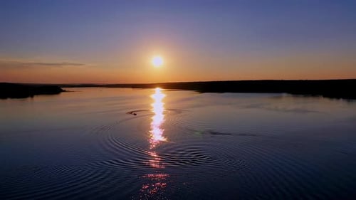 Beautiful sunset in nature. Sunny path reflects on the river in the evening.