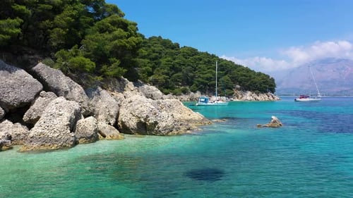 Sailboats, yachts and catamarans anchored on the shores with beach of the islands with vegetation in