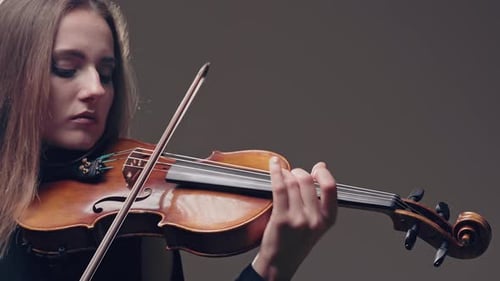 Girl Violin Playing at Studio. Woman Is Practicing Playing Musical Instrument