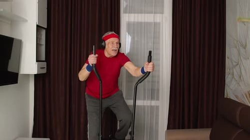Senior Man Exercising on Elliptical Machine at Home