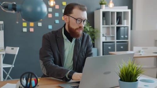Slow Motion of Businessman Working with Laptop Computer in Modern Office