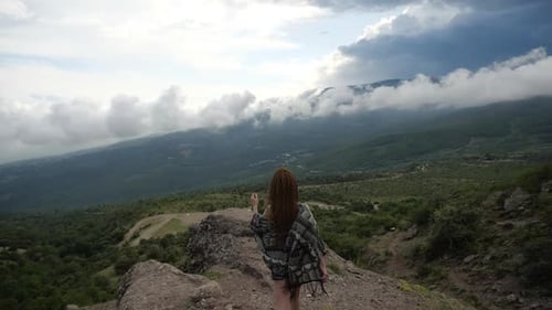 A Young Female Traveller in Short Black Shorts and Sports Boots Climbs Up a Hill