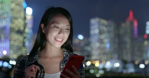 Woman Using Mobile Phone at Night in City