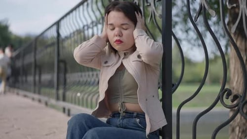 Persona pequeña estresada nerviosa con enanismo que tiene migraña sosteniendo la cabeza en las manos cerrando los ojos