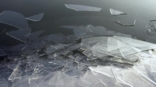 Sheets of ice shifting on frozen lake as the surface moves in winter