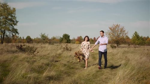 Positive Young Happy Loving Couple Walking on Meadow in Summer