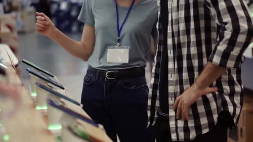 Customer and Saleswoman Looking at Phones in Store