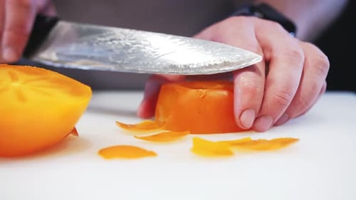 Cutting Fresh Persimmon Fruit with Silver Knife