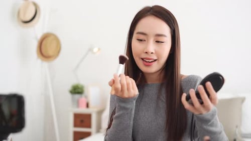Young Woman Applies Makeup in Bright Room