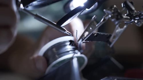 Unrecognized Successful Man Working with a Soldering Iron at His Working Place. Concept of the