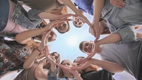 Young People Putting Their Hands in Circle on Sky Background