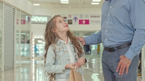 Happy Little Girl Pointing at Kids Store, Shopping at the Mall with Her Father