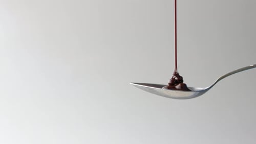 Dunkle Schokoladencreme gießt auf Löffel