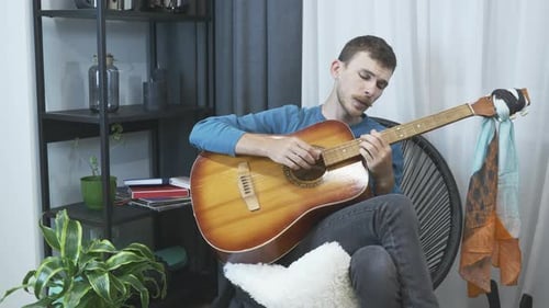 Man Plays Acoustic Guitar, Singing in Living Room