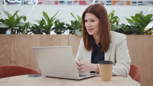 Businesswoman Having Video Call on Laptop in Cafe