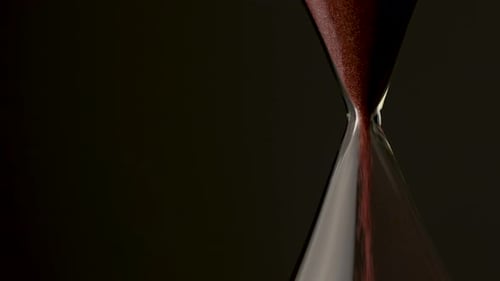 Red Sand Flowing in Hourglass Close Up