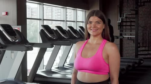 Woman Lifts Dumbbell at Gym