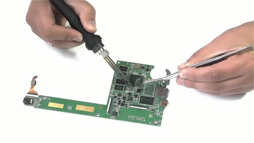 Hands Repairing Circuit Board with Soldering Iron