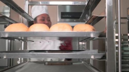 Baker Placing Buns on Rack in Commercial Kitchen