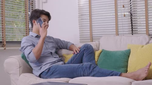 Young Man Relaxing at Home Talking on Phone