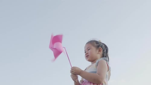 Asian child girl playing with pinwheels