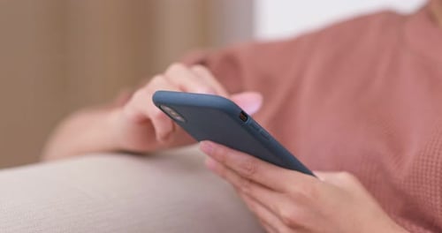 Hands Using a Smartphone with a Blue Case