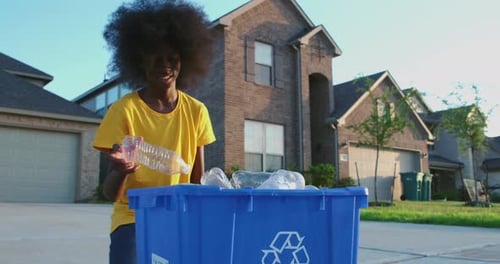 Young Adult Recycling Plastic Bottles in Neighborhood