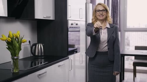 Beautiful Senior Estate Agent Showing House Keys