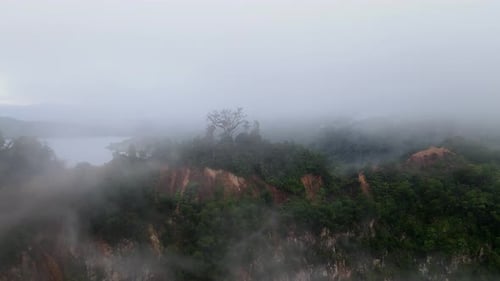 Peak of red soil hill in foggy cloud day