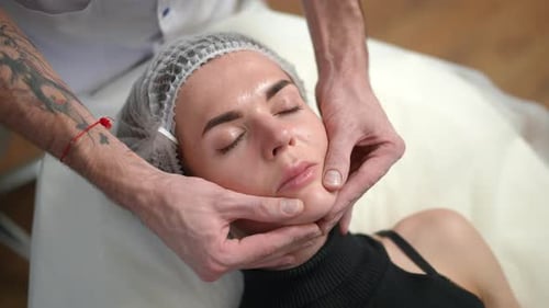 High Angle View Young Slim Beautiful Woman in Hair Cap Lying in Beauty Salon with Male Hands