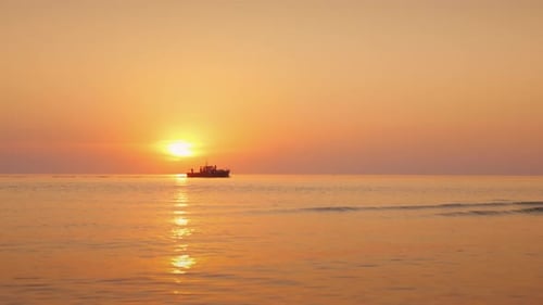 A Beautiful Sunset Over the Calm Sea, in the Distance a Lonely Boat Sails