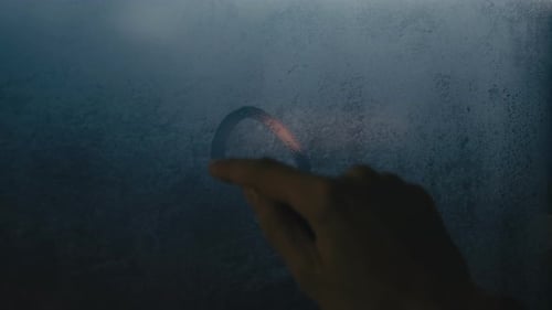 Finger Draws Heart on Foggy Window