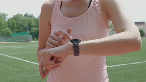 Woman Using Smartwatch on Athletic Field