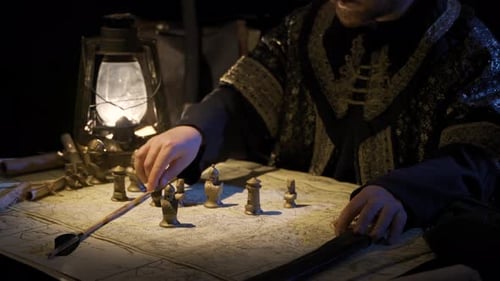 Man Plays Strategy Game with Map and Figures