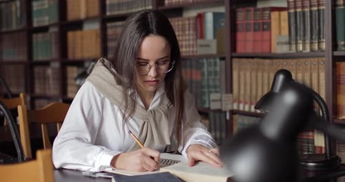Young Girl Writing in Library