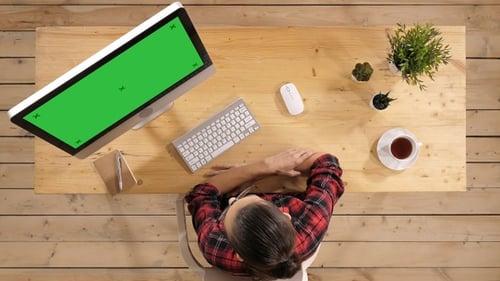 Young woman watching on computer and smiling. Green Screen