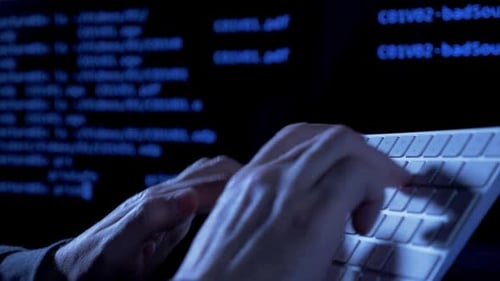 Hands Typing Code on Computer Keyboard at Night