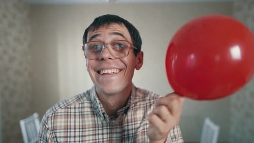 Smiling Man Holding Red Balloon Indoor