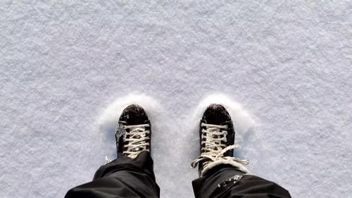 Top down view Person ice skating outdoors on fluffy snow - Pov Shot